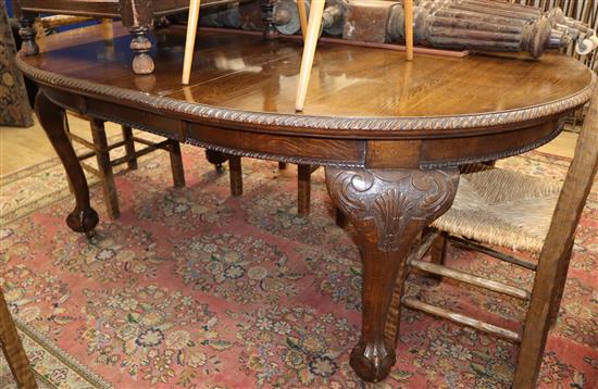 A Chippendale style oak extending dining table with one spare leaf W.190cm